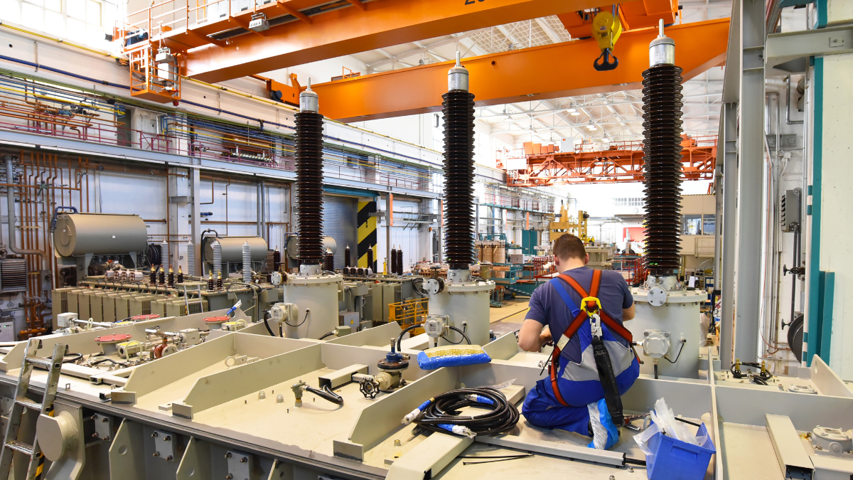 Manufacturing employee kneeling down fixing an equipment part
